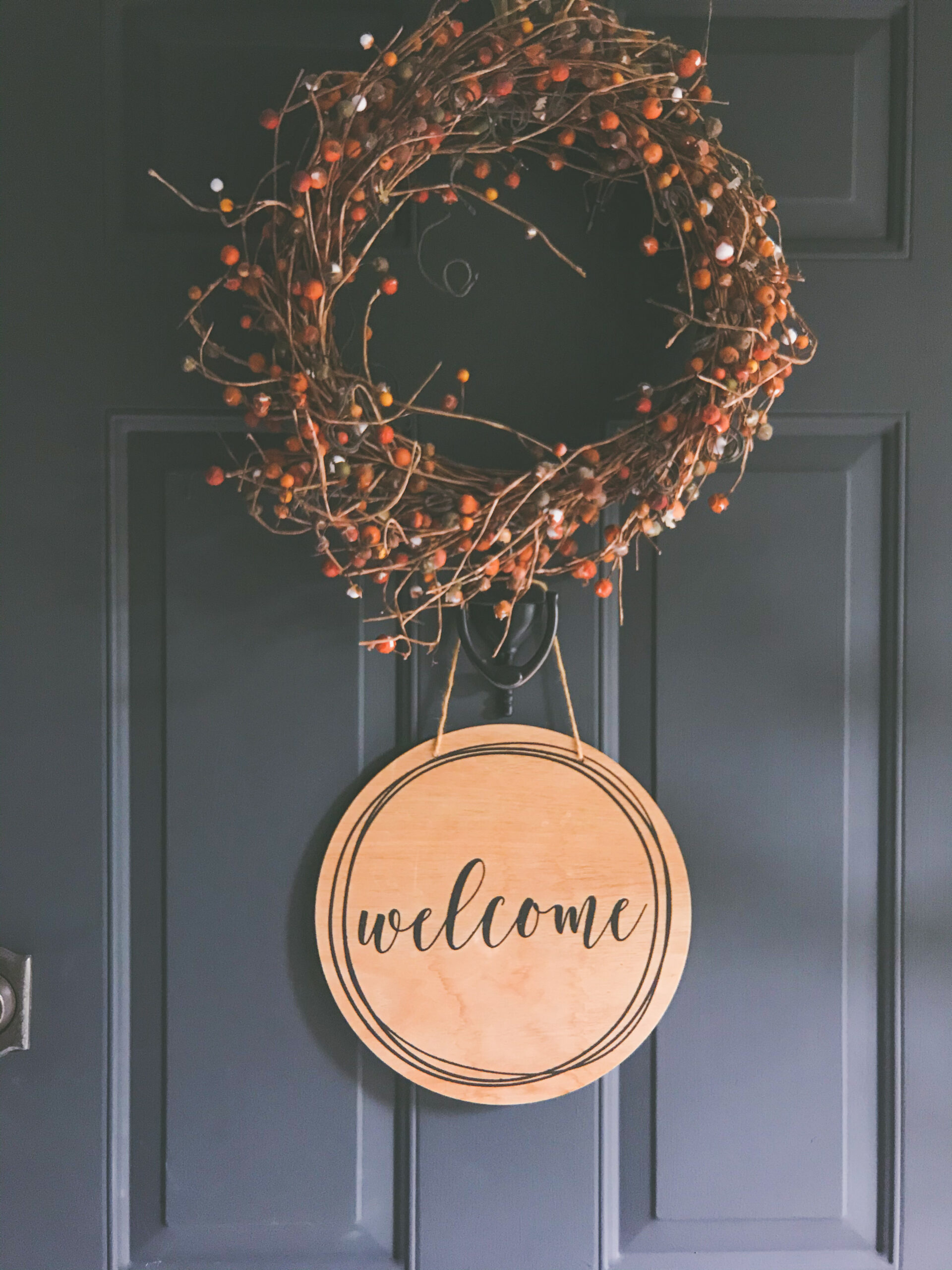 a welcome sign hanging on the front door